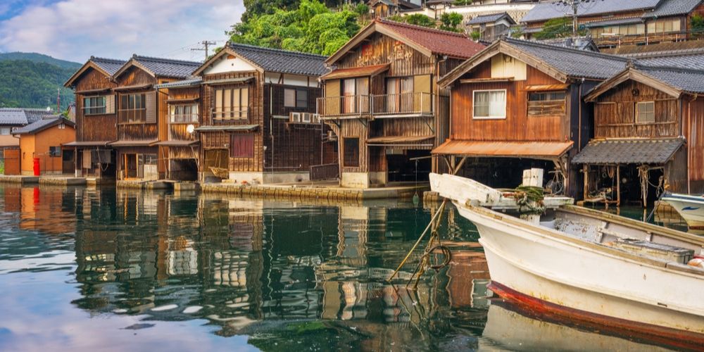 A tranquil, empty stone path in a hidden Kyoto neighborhood, lined with traditional Japanese wooden Machiya houses and soft evening lanterns.
