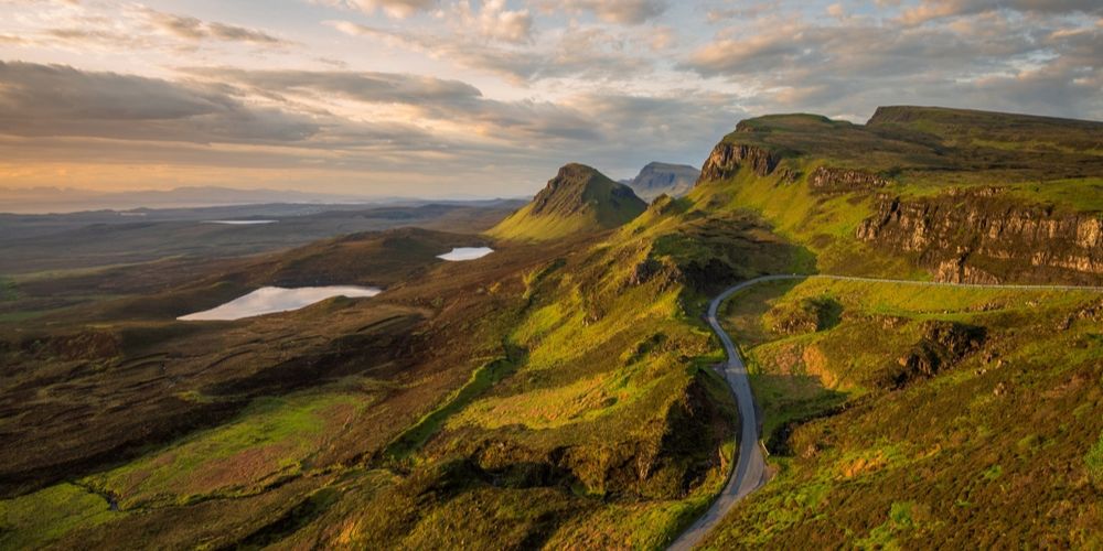 The vast, rolling landscapes of the Scottish Highlands featuring a quiet loch and misty mountains, capturing a sense of peaceful isolation for couples.